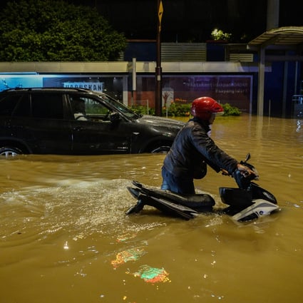 A motorcyclist crosses a flooded street after heavy rains in Kuala Lumpur. Photo: DPA
