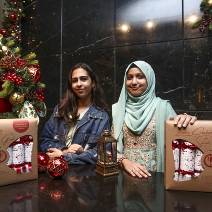 Students Aesha Ijaz (left) and Mehreen Hassan with the Christmas crackers their team produced through a Zubin Foundation project. Photo: Jonathan Wong
