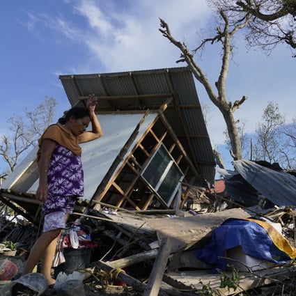 A woman salvages parts of her home damaged due to Typhoon Rai, in Talisay, Cebu province, Philippines. Photo: AP