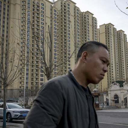 A pedestrian walks past apartment buildings at the City Plaza development of the highly indebted China Evergrande Group in Beijing. Photo: Bloomberg
