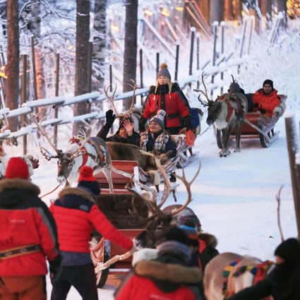 Tourists ride in sleighs pulled by reindeer at Santa Claus Village in Rovaniemi, Finnish Lapland, on November 29, 2021. Photo: Kyodo