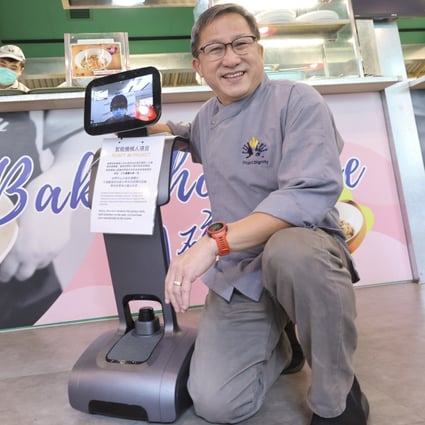 Dignity Kitchen founder Koh Seng Choon (right) with paraplegic Eddie Lau (on the tablet screen) who operates Temi, the robot, remotely. Photo: May Tse