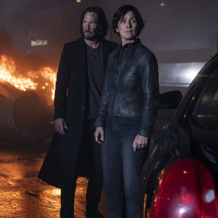 Keanu Reeves (left) and Carrie Anne Moss in a scene from The Matrix Resurrections (category: IIB), directed by Lana Wachowski and co-starring Jessica Henwick.