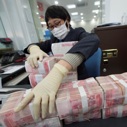 A staff member arranges stacks of Chinese yuan banknotes at a bank in Nantong, Jiangsu province. Photo: Reuters