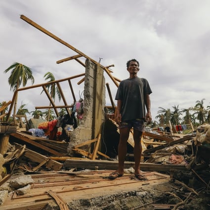 A man stands on his damaged house after Typhoon Rai hit Surigao City, southern Philippines. Photo: AP