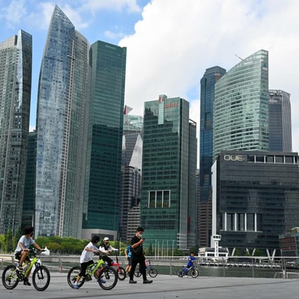 People ride bicycles along the promenade at Marina Bay in Singapore, as the city state learns to live with the virus. Photo: AFP