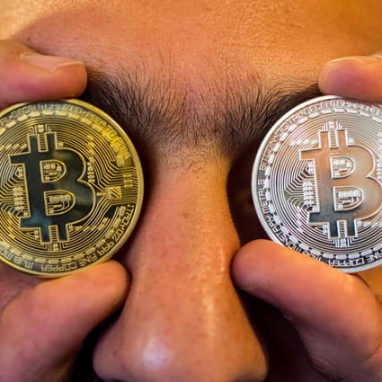 A person holding a visual representation of the digital crypto-currency Bitcoin. Photo: AFP