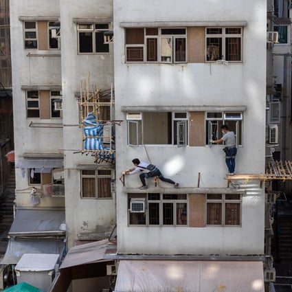 Workers dismantle bamboo scaffolding on a block of flats in Hong Kong on December 8. Hong Kong must increase its supply of affordable housing, as it is clear the central government is serious about the city “bidding farewell” to subdivided flats and cage homes. Photo: EPA-EFE