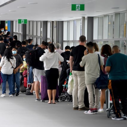 Travellers wait in line for Covid-19 screening outside the departures terminal at Sydney International Airport. At least 80 flights were cancelled on Friday. Photo: EPA-EFE