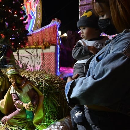 A mother and her child look at a nativity scene during the Tha Rae star parade in Thailand’s Sakon Nakhon province on Thursday. Photo: Vivat Thongantang