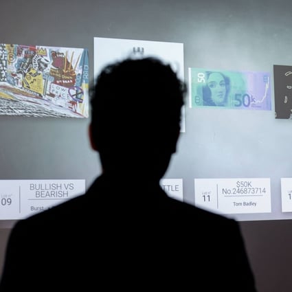 A visitor looks at NFT digital artworks at the Millon Belgique auction house, in Brussels on May 18, 2021. Photo: AFP
