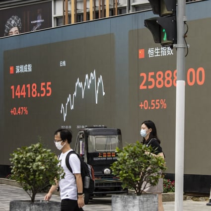 Pedestrians walk past a public screen displaying the Shenzhen Stock Exchange on August 18, 2021, Photo: Bloomberg