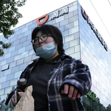 A woman walks past the headquarters of Didi in Beijing on July 16. Photo: AP