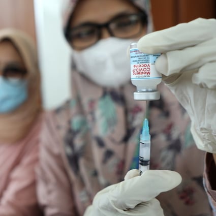 A health care worker prepares a dose of Covid-19 vaccine in Indonesia. Photo: EPA