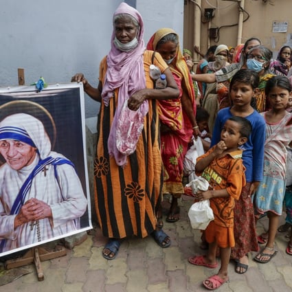 Homeless people gather beside a portrait of Saint Teresa, the founder of the Missionaries of Charity. Photo: AP 