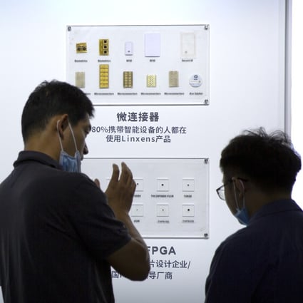 People check out semiconductors on display from Tsinghua Unigroup at an event in Beijing on September 19, 2020. Photo: AP