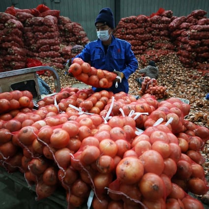 A vendor loads bags of onions at a market in Shenyang, in China’s Liaoning province, on December 9. Disruptions to supply chains have been less intense in East Asia compared to the US and elsewhere. Photo: AFP