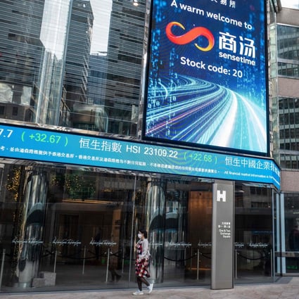 People walk beneath a message welcoming Chinese artificial intelligence group SenseTime to the Hong Kong stock exchange on December 30. Photo: AFP