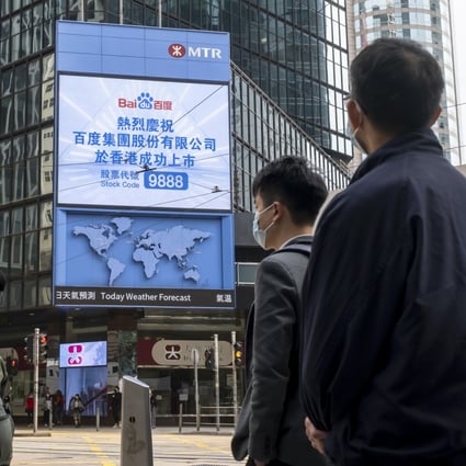 Pedestrians in front of a display for the listing of Baidu on the Hong Kong Stock Exchange on March 23, 2021. Photo: Bloomberg