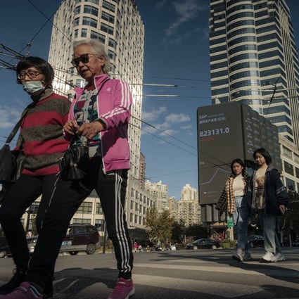 People walk on the street next to the large screen showing stock data in Shanghai in November 2021. Photo: EPA-EFE