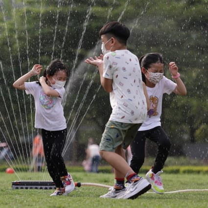 Children enjoy being drenched by sprinkler at the Velodrome Park in Tseung Kwan O in May. Photo: May Tse