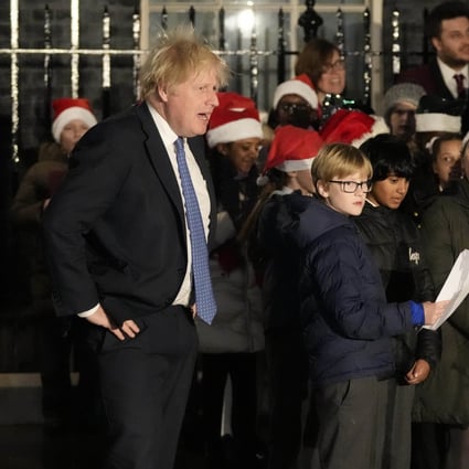 Britain’s Prime Minister Boris Johnson with a children’s choir during a ceremony to switch on Christmas tree lights in London last month. His government has now announced secondary school pupils will have to wear face masks in classrooms when they return to school this week. Photo: AP