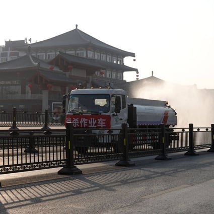 A truck sprays disinfectant on a street in Xian, in northern Shaanxi province, on December 31, 2021. China’s stringent measures against Covid-19 are having spillover effects, such as disrupting work at Samsung’s plants in Xian and weakening the Thai and South Korean currencies. Photo: AFP