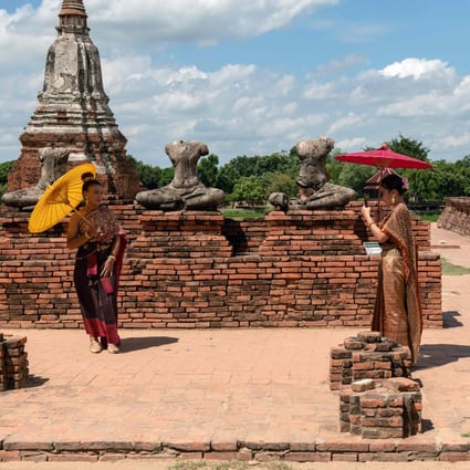 Visitors carrying sun umbrellas at the 17th century Wat Chaiwatthanaram temple complex in the ancient capital of Ayutthaya, north of Bangkok, Thailand. Photo: AFP