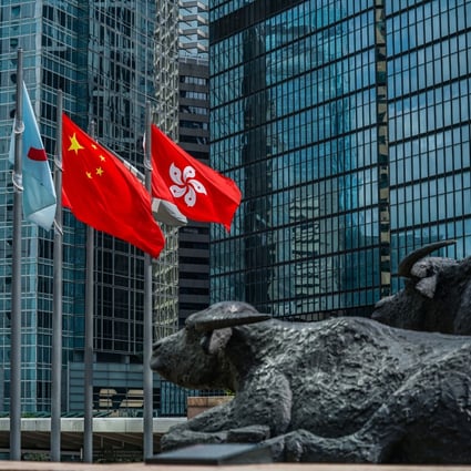 The flag of the Hong Kong Special Administrative Region (right) alongside the flag of China (centre) outside the Exchange Square complex, which houses the Hong Kong Stock Exchange on May 29, 2020. Photo: Bloomberg.