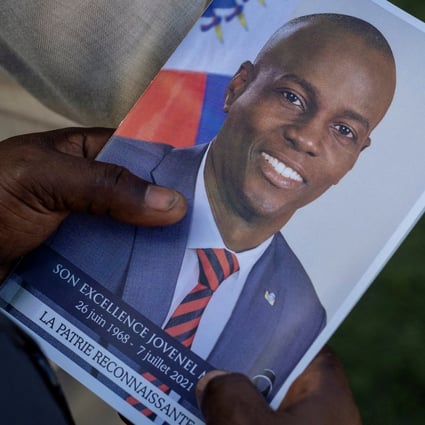 A person holds a photo of late Haitian President Jovenel Moise during his funeral at his family home in Cap-Haitien in July. Photo: Reuters