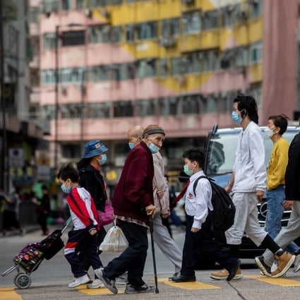 Pedestrians cross a road in Hong Kong on December 7. The Hong Kong government is worried about a Covid-19 fifth wave. Photo: Bloomberg
