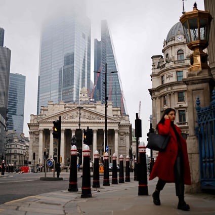 A pedestrian walks near the Royal Exchange and the Bank of England in the City of London on December 28, 2020.  Magical arithmetic has helped central banks worldwide arm-wrestle the pandemic recession with negligible debt-service costs. Photo: AFP