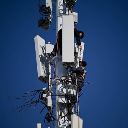 Workers are seen on a 5G tower at Shougang Park, one of the sites for the Beijing 2022 Winter Olympics, in Beijing on December 1, 2021. Photo: AFP 