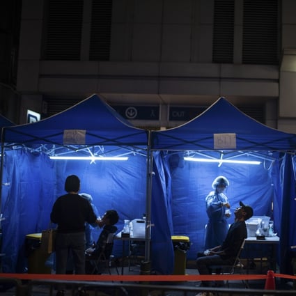 Health workers administer Covid-19 tests outside a building placed under lockdown in Hong Kong. Photo: Bloomberg