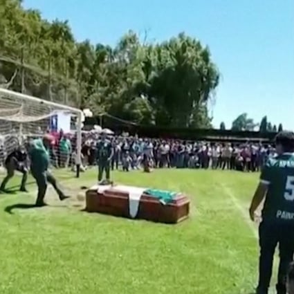 A man kicks a ball against the late player Jaime Escandar’s coffin during a final send off given by his Aparicion Paine team in Paine, Chile. Photo: Reuters