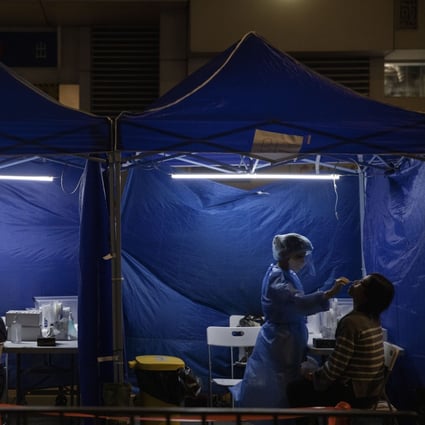 Health workers administer Covid-19 tests outside a building placed under lockdown at the City Garden housing estate in North Point, Hong Kong, on January 6. Is Hong Kong’s zero-Covid battle doomed? Photo: Bloomberg
