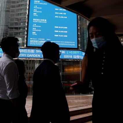 People wearing protective masks walk past screens outside the Hong Kong Exchanges, following the coronavirus outbreak, in Hong Kong’s financial Central district on September 14, 2020. Photo: Reuters