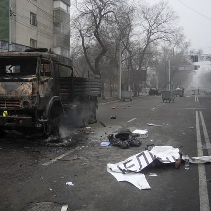 A body, covered by a banner, lays near a military truck burned during protests in Almaty, Kazakhstan in recent days. The Central Asian nation has experienced its worst street protests since gaining independence from the Soviet Union three decades ago, with reports of 164 people killed. Photo: AP