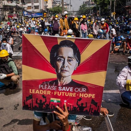 A protester holds a poster featuring Aung San Suu Kyi at a demonstration against the military coup in Yangon last year. Photo: AFP