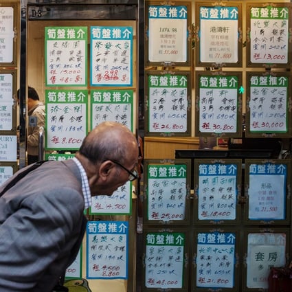 A man looks at residential property advertisements displayed in the window of an estate agency in North Point. Photo: Bloomberg
