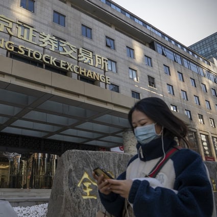 A woman walks past the Beijing Stock Exchange in Beijing on December 13. 2022 could be a year of redemption for Chinese assets. Photo: Bloomberg