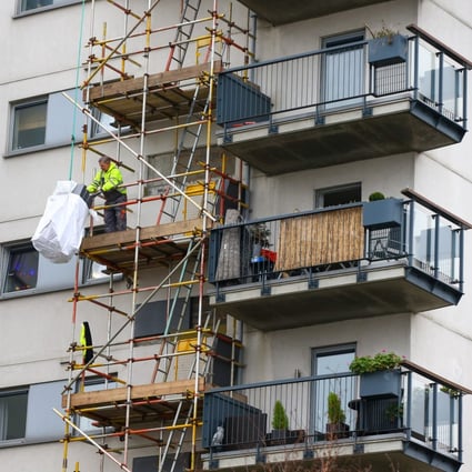 A construction worker inspects cladding at Royal Artillery Quays residential apartments in London. Photo: Bloomberg