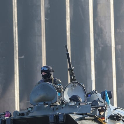 A Kazakh soldier in an armoured vehicle outside the Almaty city administration headquarters, which was set on fire during recent protests, Photo: Reuters