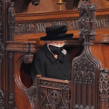 Queen Elizabeth sits alone, in one of the most striking images from the funeral of her husband, Prince Philip, in St George’s Chapel at Windsor Castle in April. Photo: TNS