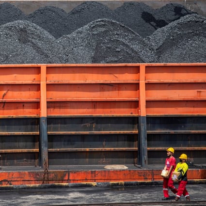 Workers walk near a tugboat pulling coal barges at a port in Palembang, Indonesia. Photo: Reuters