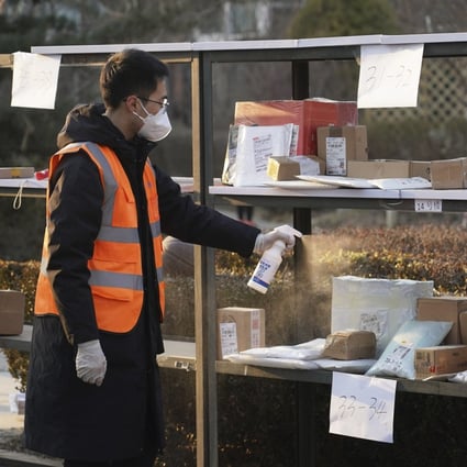 Parcels are sprayed with disinfectant in Beijing’s Haidian district. Photo: AP