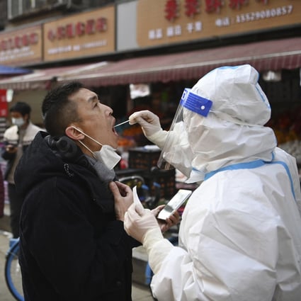 A medical worker collects swab sample from a man at a mobile Covid-19 testing site in Xian. The Chinese city has been under lockdown since late December, making it difficult for some residents to access food and basic supplies. Photo: Xinhua
