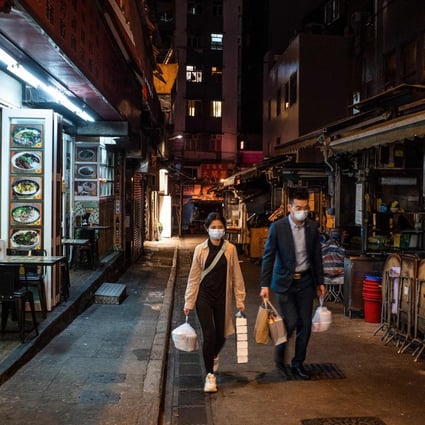 People carry takeaway dinners through a deserted Central district in Hong Kong on January 9, with dining restrictions in place once again. Photo: TNS