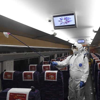 Workers in protective gear disinfect a train in  southern China’s Guangxi Zhuang autonomous region. Photo: Xinhua via AP 
