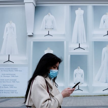A woman wearing a protective face mask walks on the Champs Elysees in Paris. Photo: Reuters